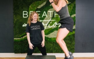 physical therapist watching female client perform box jump