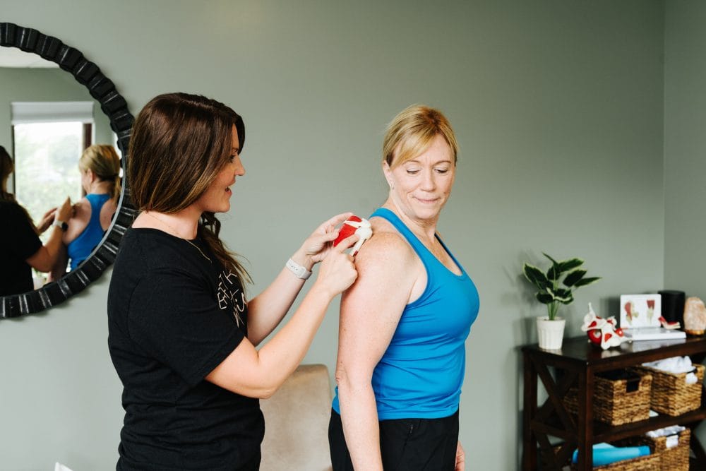 physical therapist explaining shoulder anatomy to a female client