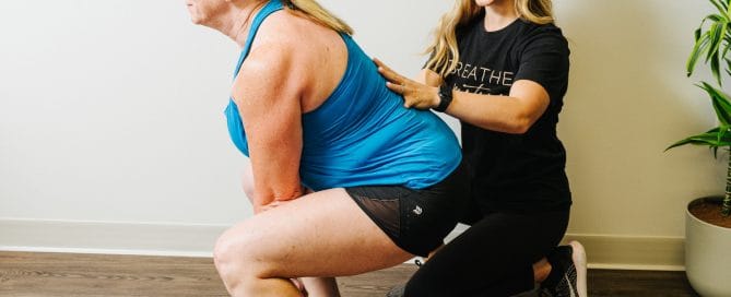 physical therapist assisting women with deadlift form