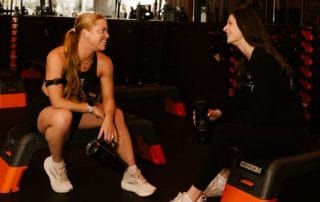 two orange Theory clients chatting