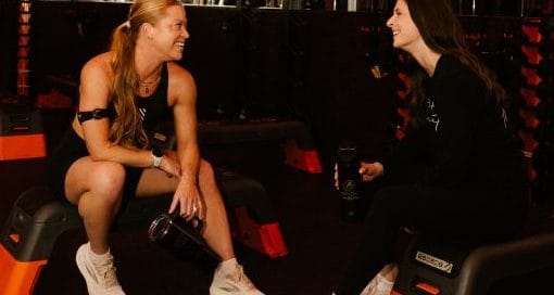 two orange Theory clients chatting